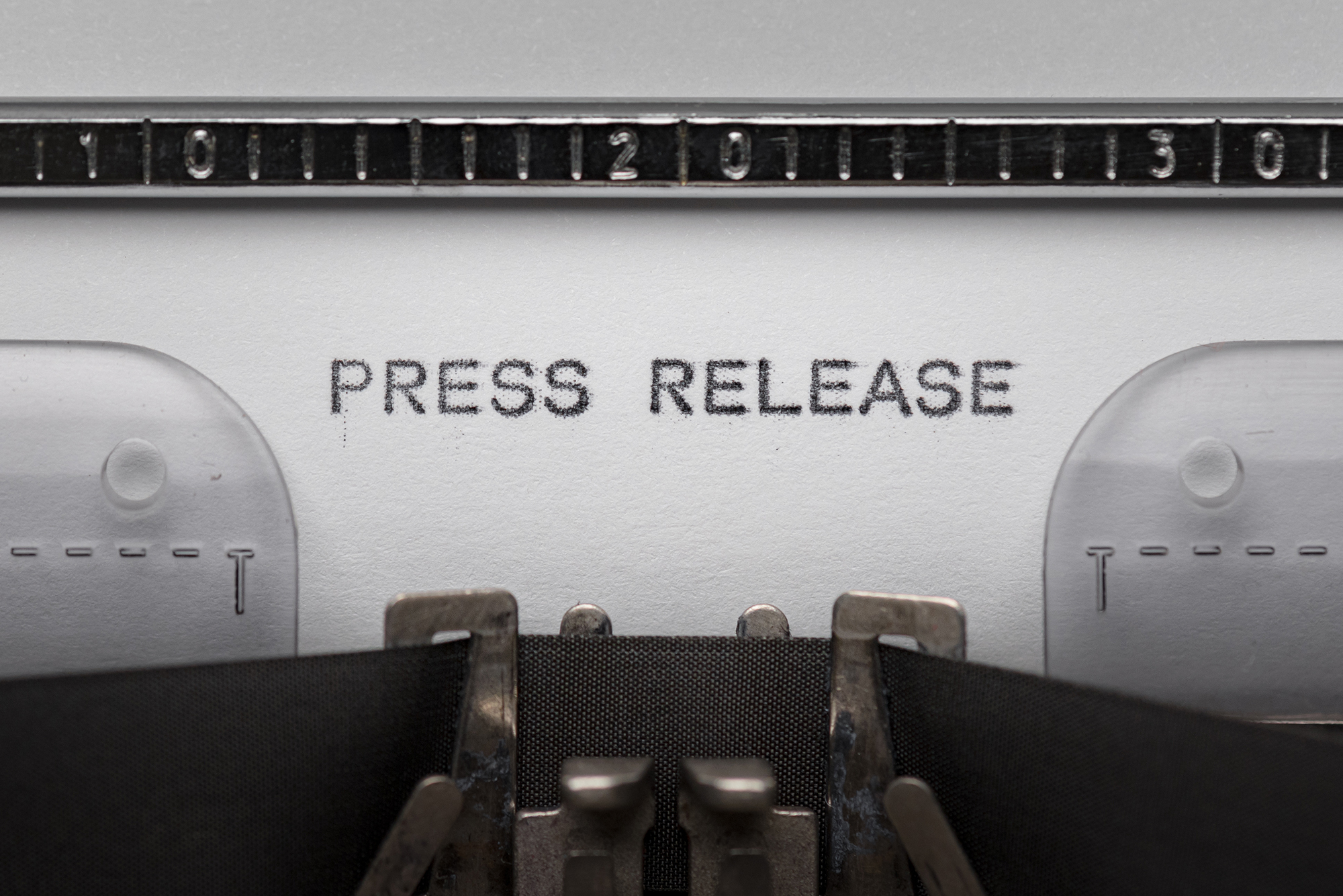 Image of paper in a type writer with the words Press release.