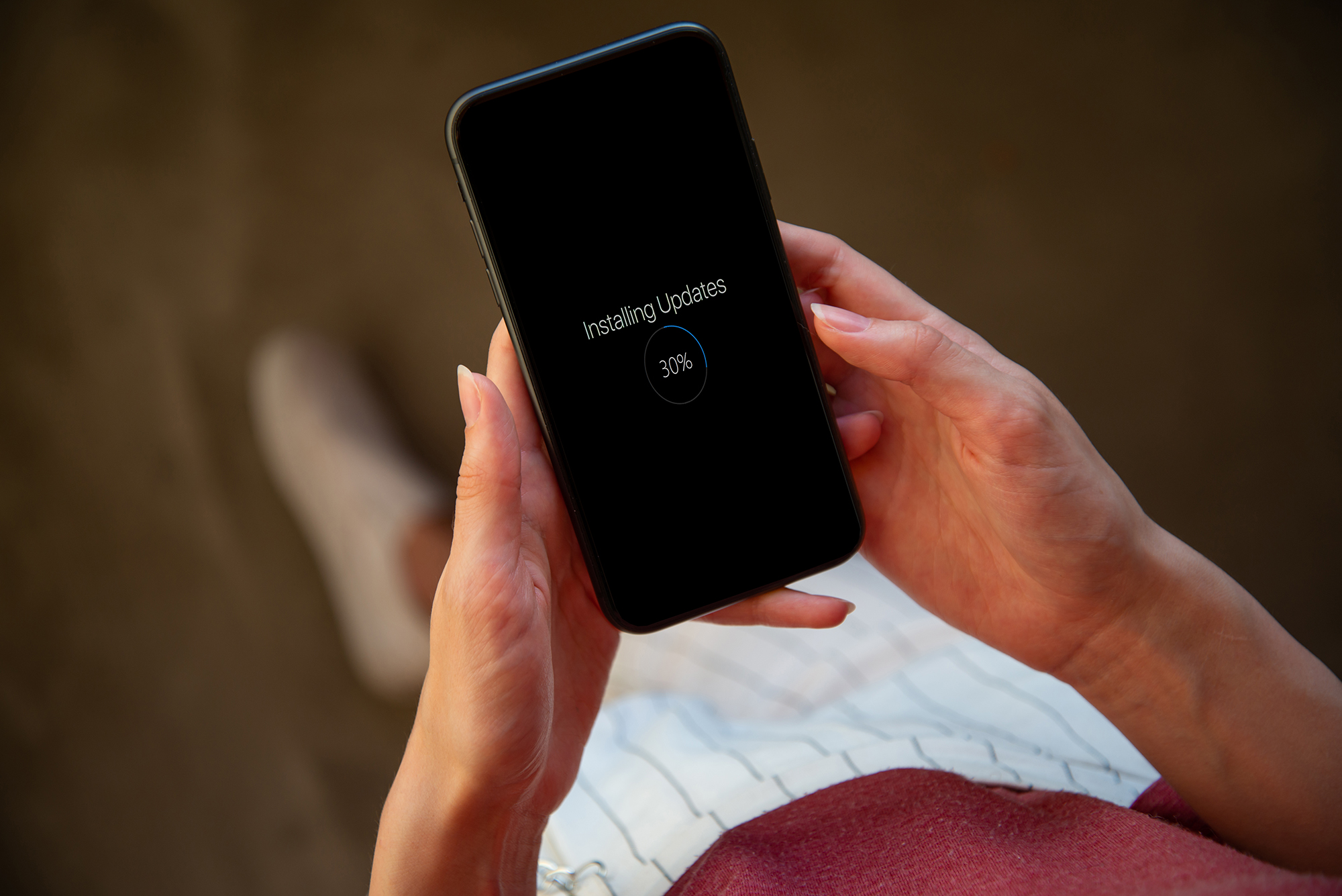 Lady holding a phone with updates in progress